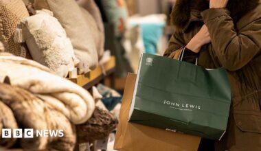 Woman with a John Lewis shopping bag in the department store