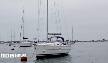 A sailing boat attached to a buoy in the harbour