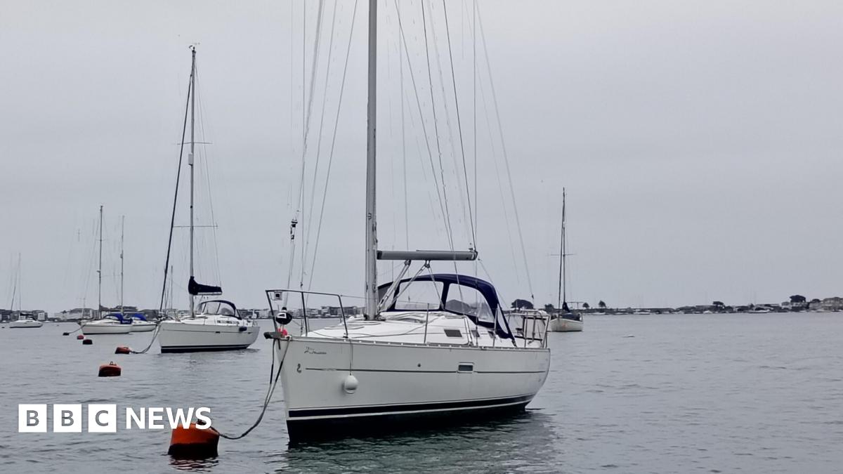 A sailing boat attached to a buoy in the harbour