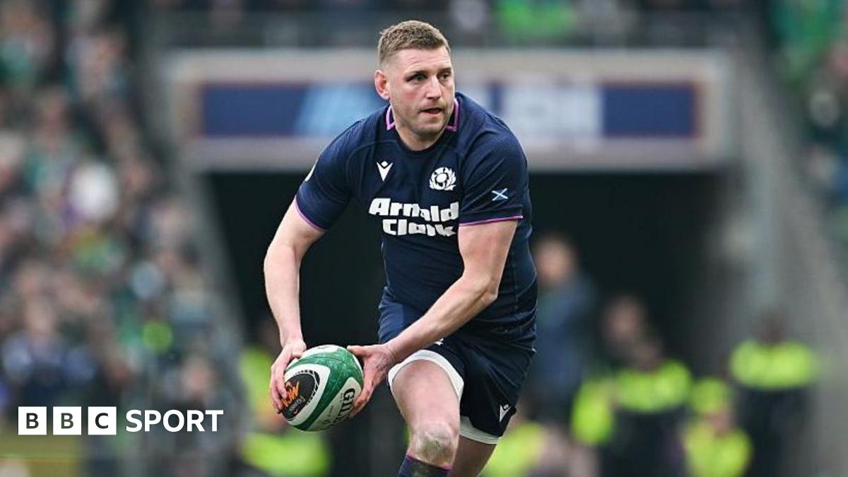 Finn Russell runs and holds the ball in two hands to his right hand side ready to pass the ball during Scotland's Six Nations match against Ireland