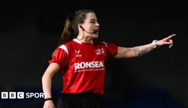 Referee Tara Jones speaking into her microphone attached to her ear while pointing towards a player while in charge of London Broncos v Widnes Vikings.
