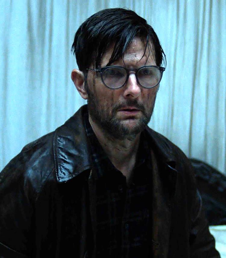 Adam Scott's Ohm looking worried while covered in water in a white room in Hokum