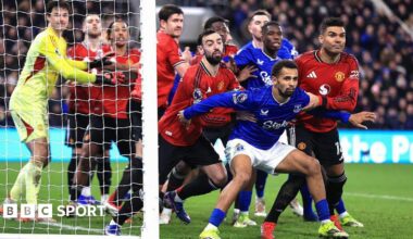 Iliman Ndiaye of Everton holds back Bruno Fernandes and Casemiro of Manchester United as players jostle at a corner kick