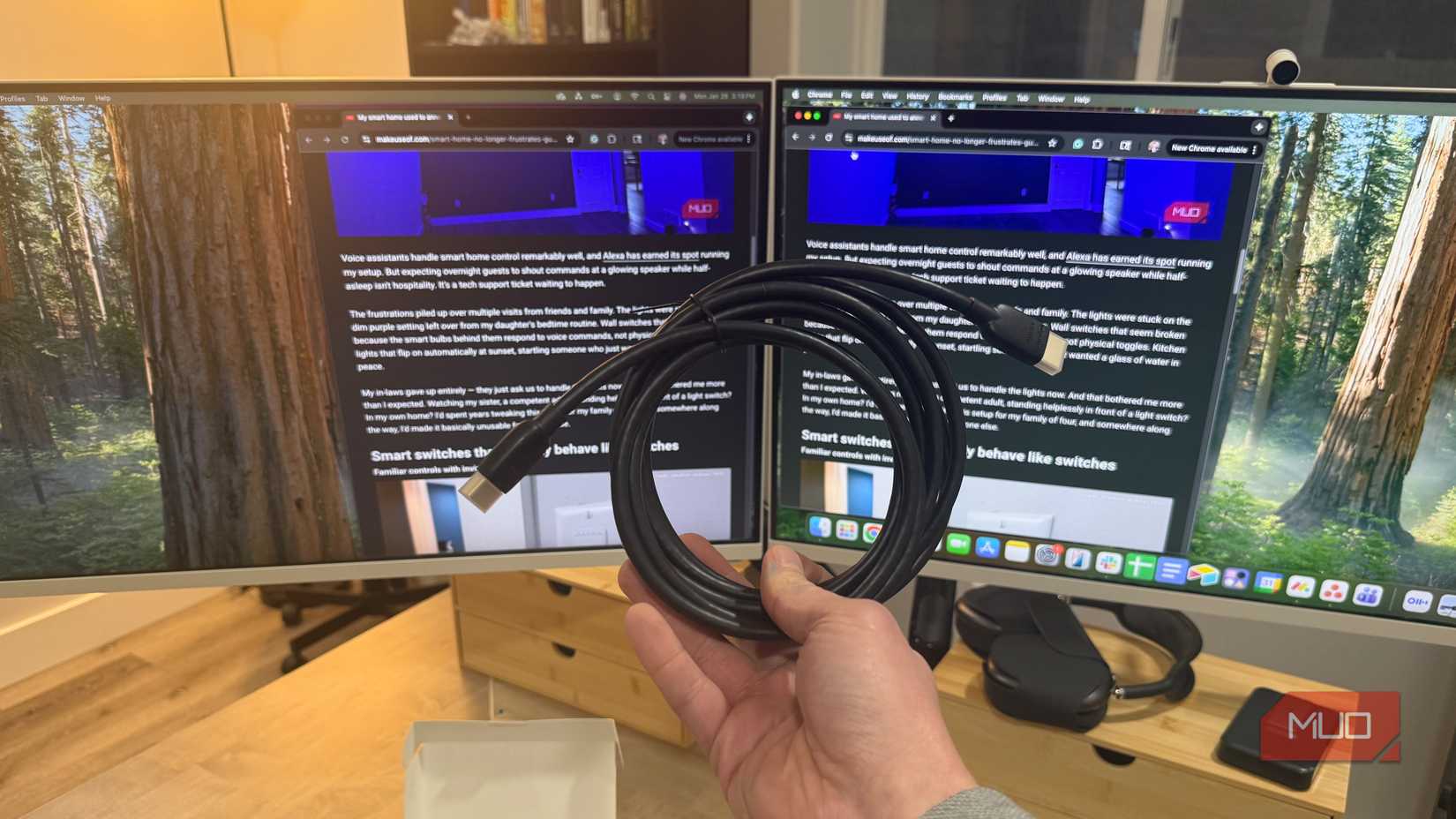 amazon basics hdmi cable in hand with 2 monitors in background
