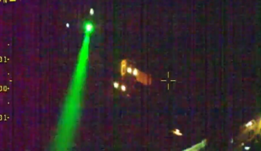 A picture shows darkness, with some lights from houses, and a green laser across the left of the picture. The top right of the picture says West Mercia Police.