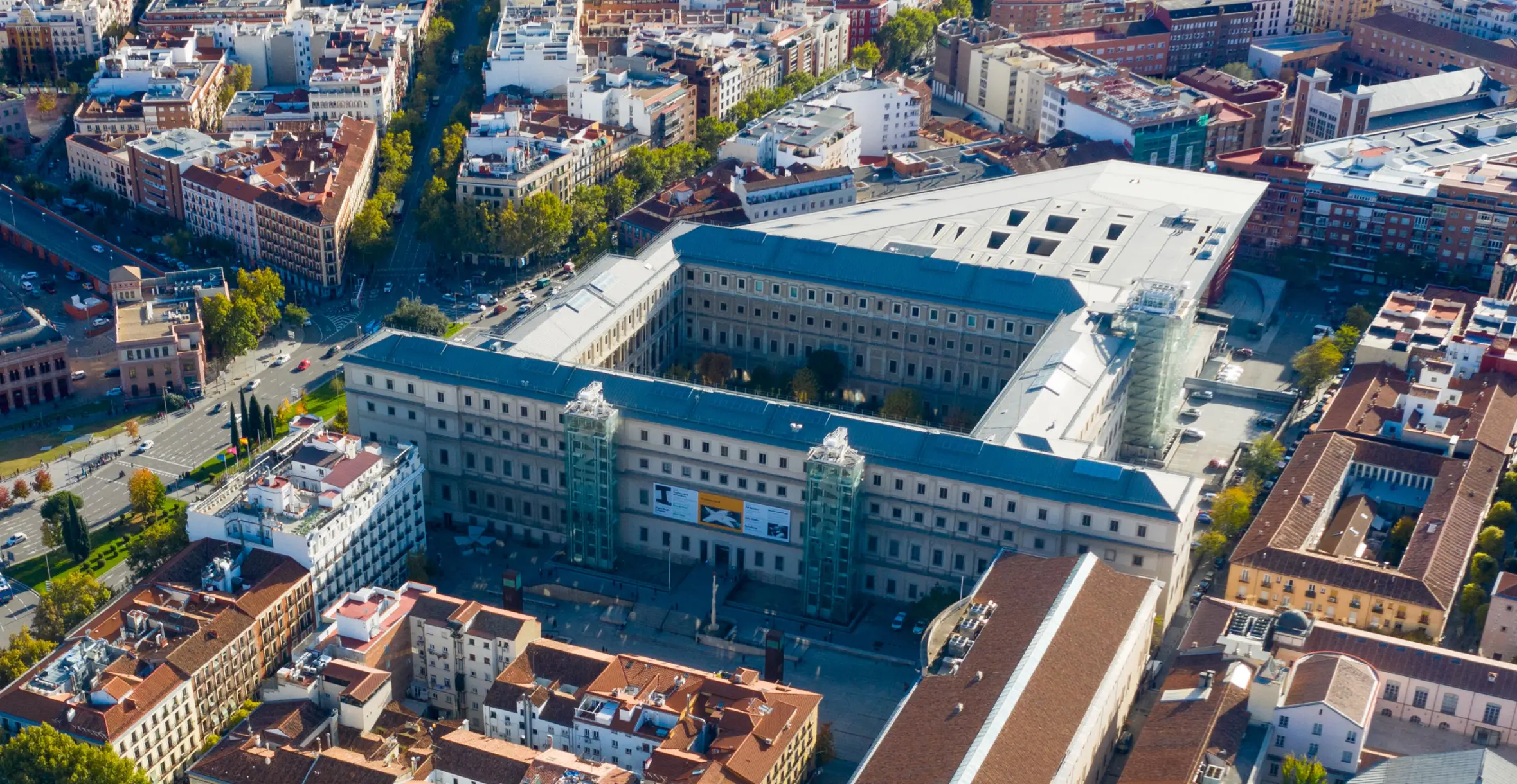 Aerial view of Museo Nacional Centro de Arte Reina Sofia in Madrid, Spain, surrounded by city buildings and streets.