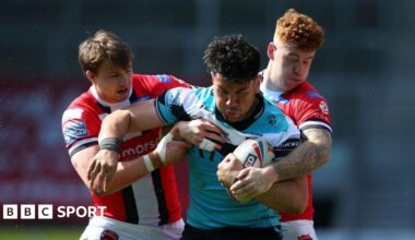 Goole Vikings player Andre Savelio holds onto the ball tenaciously in the blue, black and white of Hull FC as two Salford players try to rip it out of his hands