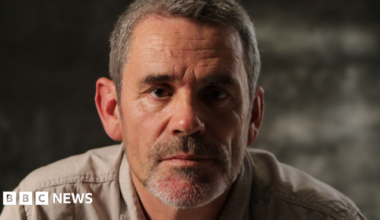 Paul Conroy poses for a headshot. He has short greying hair and stubble.