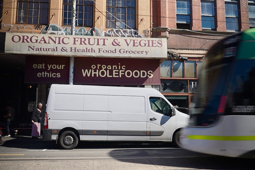 A van parked in front of a business.