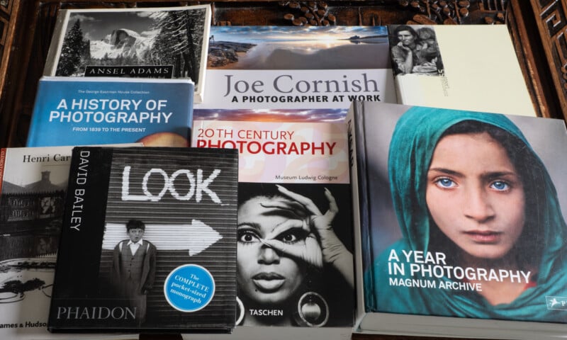 A collection of photography books is arranged, including titles like "A History of Photography," "20th Century Photography," "A Year in Photography," and "LOOK," with covers featuring photos and portraits.