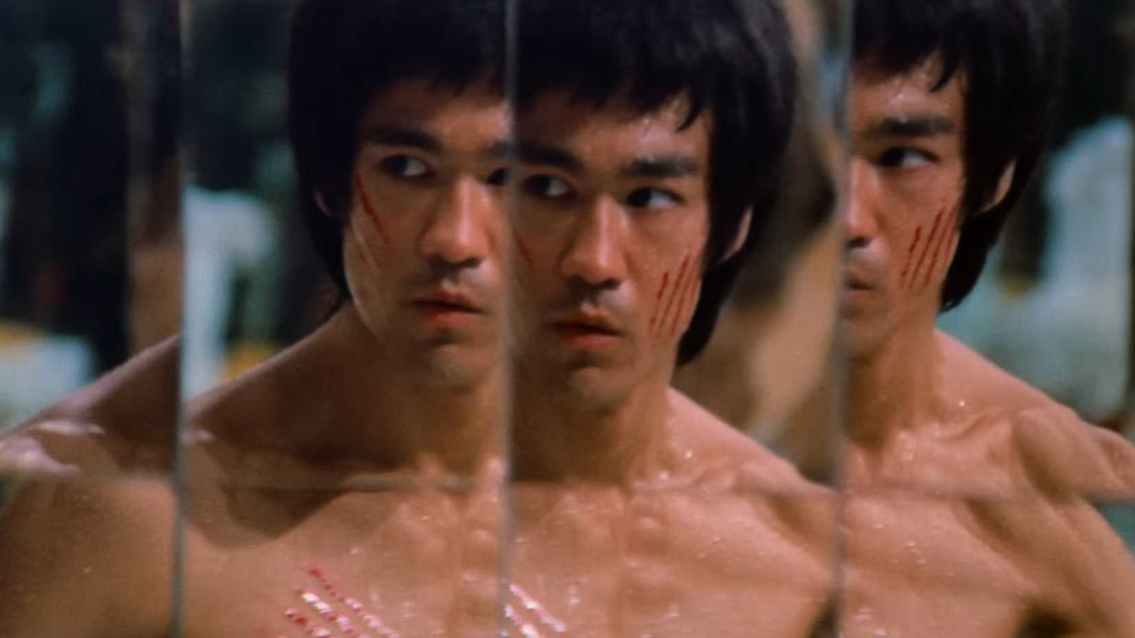 Bruce Lee with a scratched face exploring Hans mirror maze in Enter the Dragon