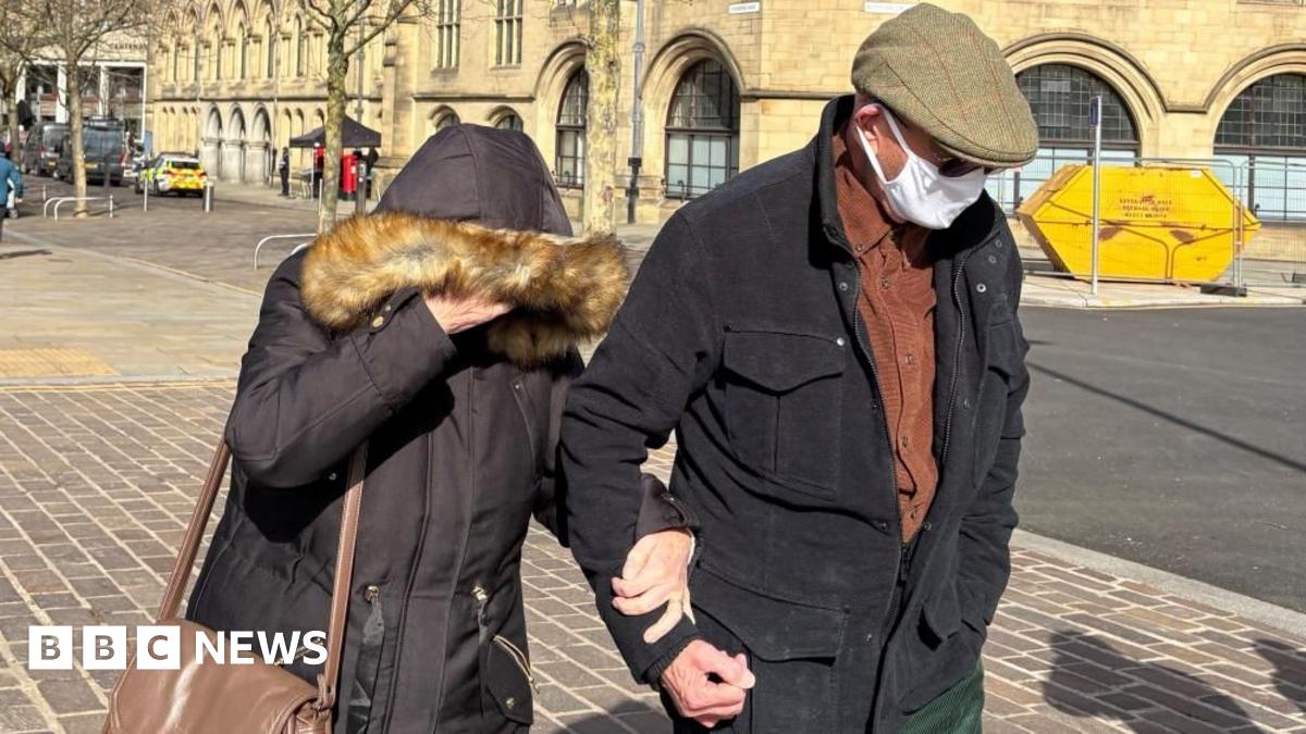Fyona and Michael Bairstow leave Bradford Magistrates' Court. Fyona has her coat hood pulled over her face, while Michael is wearing a Covid-style face mask, dark glasses and a brown flat cap.