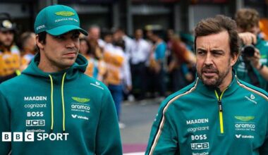 Lance Stroll and Fernando Alonso walk in the pit lane