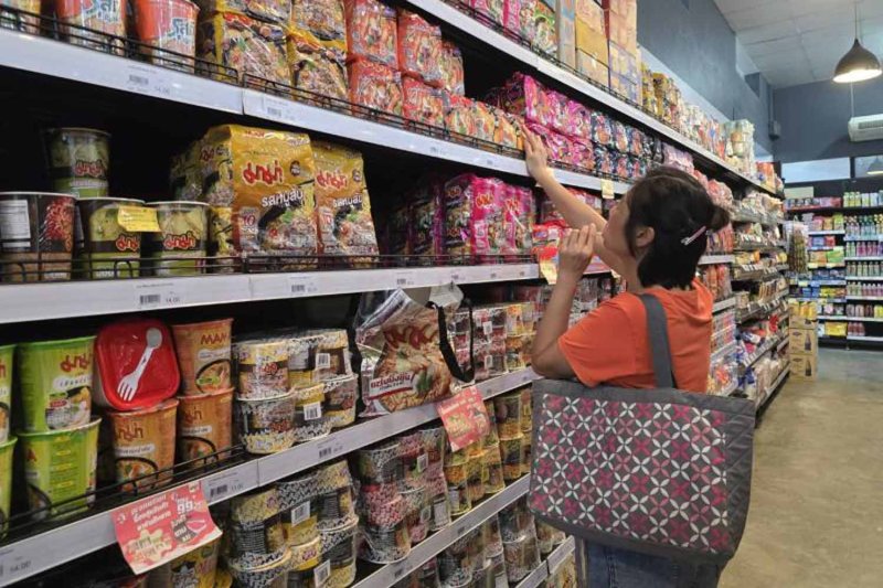 A consumer shops for instant noodle products at a Bangkok supermarket. They are among products deemed essential and subject to a price freeze as the government tries to ease the burden of rising fuel-related costs on consumers. (Photo: Somhatai Mosika)