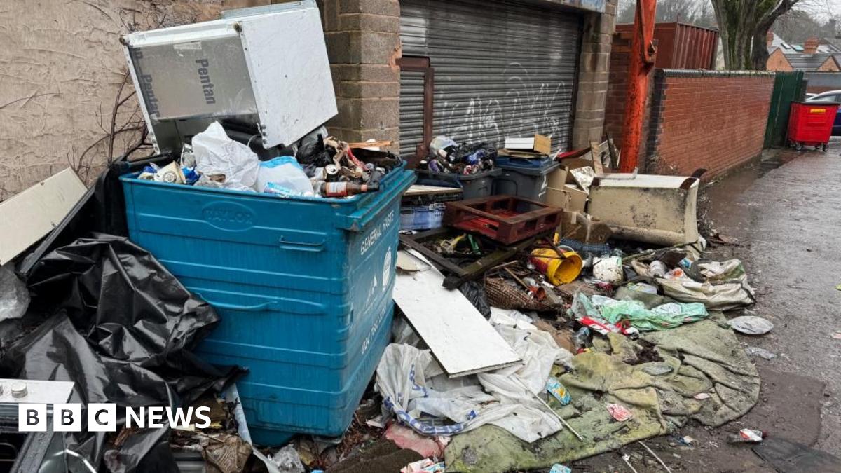 Contractors work to remove a pile of waste from Watery Lane, on the outskirts of Lichfield in Staffordshire.