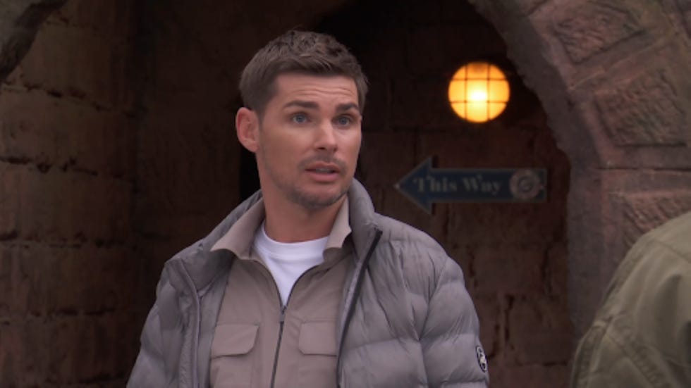 hollyoaks ste hay person standing near an archway with a directional sign