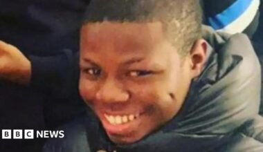 Camron Smith smiling, wearing a black puffer coat.