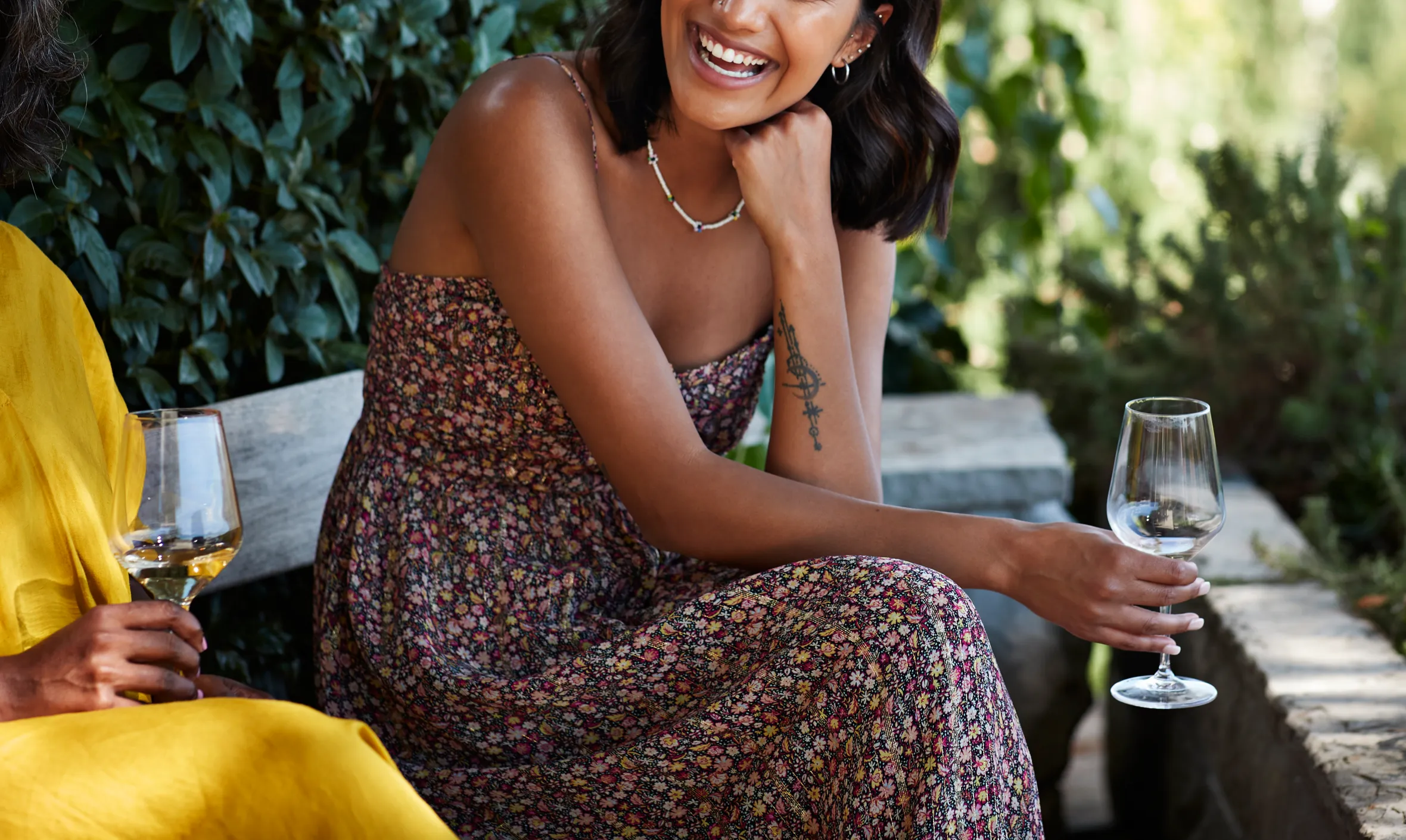 Young woman with wineglass laughing in a party setting.