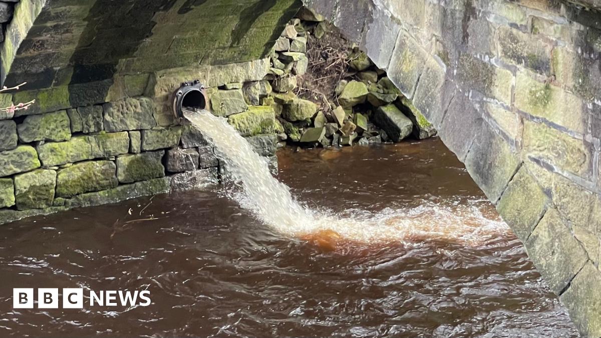 A combined sewer overflow pipe discharging fast flowing water into the River Calder at Hebden Bridge. The water looks comparatively clean and is likely to be a mixture of rainwater and wastewater.