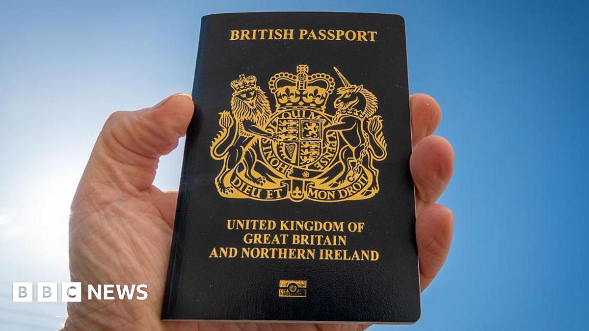 A man holds a post-Brexit United Kingdom issued passport - the British passport is now a non-EU passport with a blue cover and a gold Royal crest.