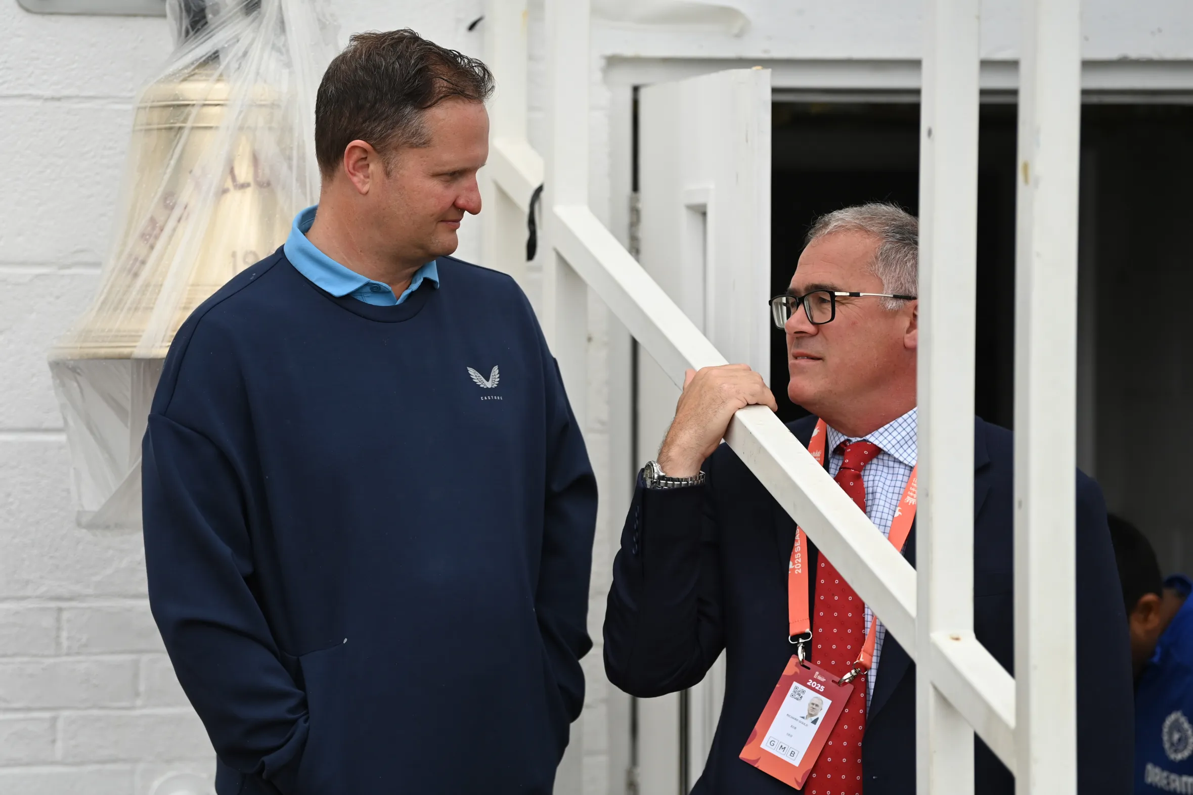 Director of Cricket Rob Key speaking with Chief Executive Officer Richard Gould during a cricket match.