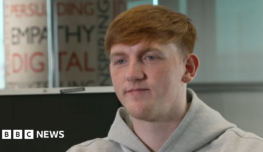 A teenage girl in school uniform stares at a phone