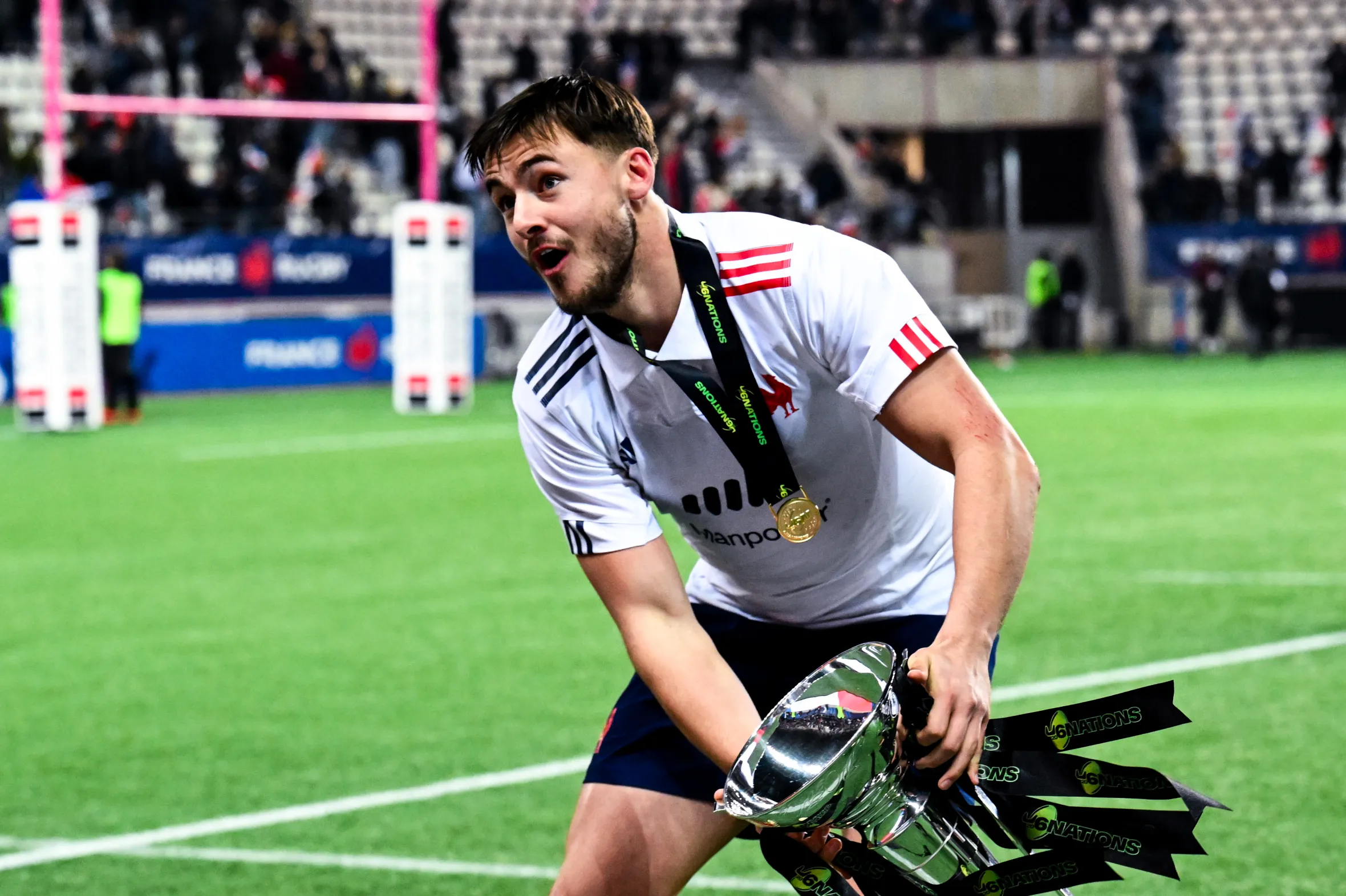 Oliver Cowie holding the U20 Six Nations trophy and wearing his medal.