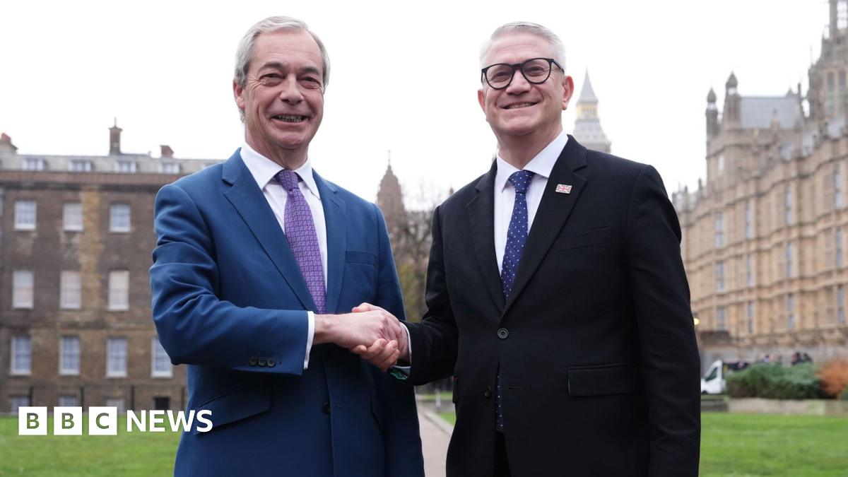 Two men in suits shake hands on College Green in Westminster