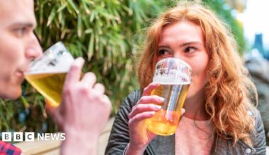 A man and a woman drinking alcohol-free beer in a beer garden
