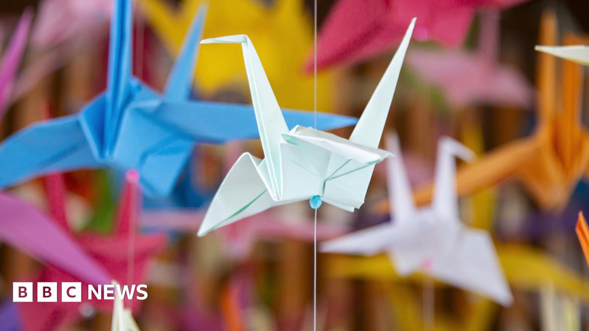 Colourful origami paper cranes hanging in a display