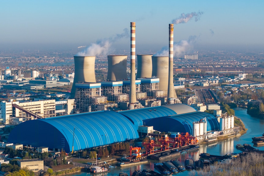 Chimneys and cooling towers emit smoke and vapor at a power station.