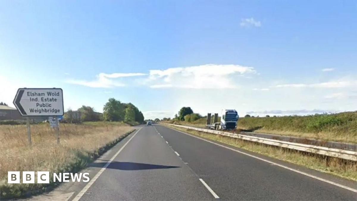 The A15 dual carriageway with a sign pointing to the Elsham Wolds Industrial Estate. The sky is blue with some clouds.