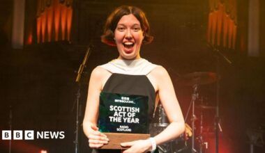 Alice Faye wearing a black and white dress holding the trophy for BBC Introducing Scottish Act of the Year.