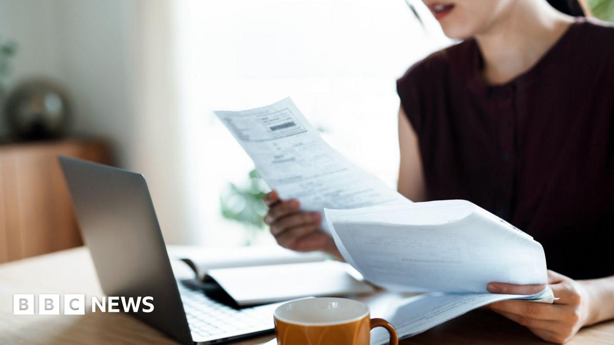 Person looking at bills with a laptop open in front of them