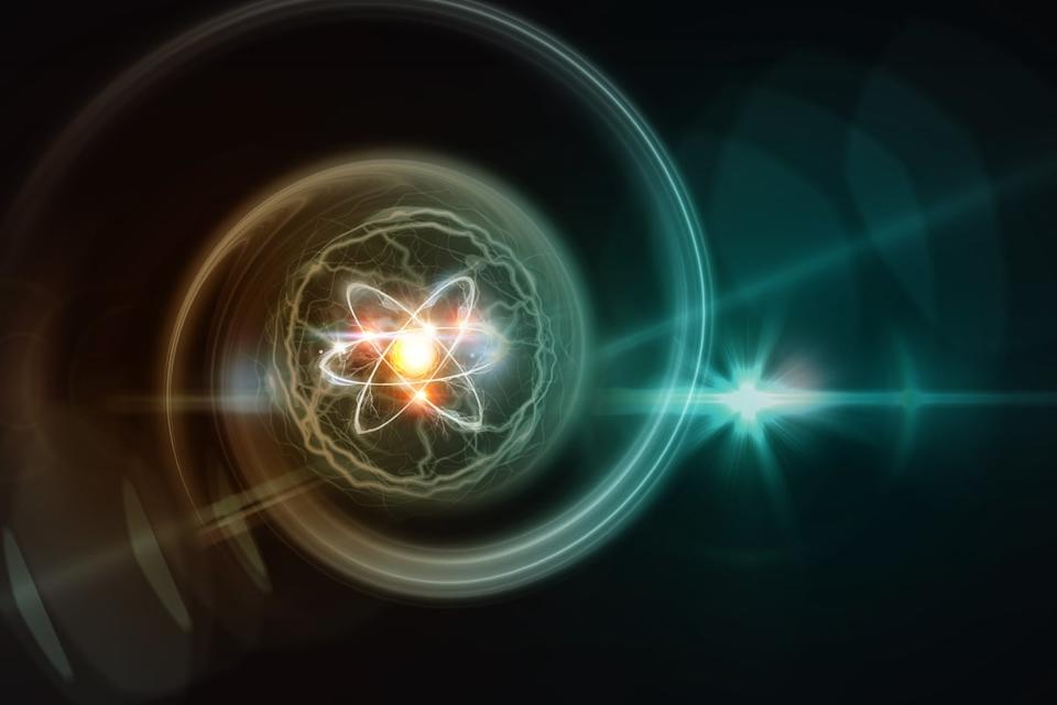 An atom of energy floating around with swirls of light around it. 