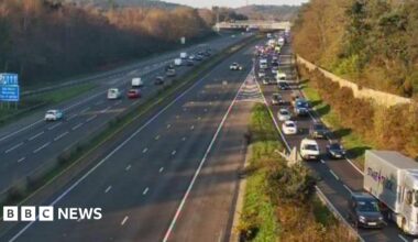 A closed motorway carriageway. Traffic is queing on the right hand side to leave the road.