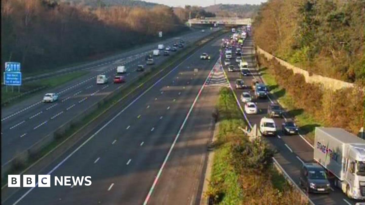 A closed motorway carriageway. Traffic is queing on the right hand side to leave the road.