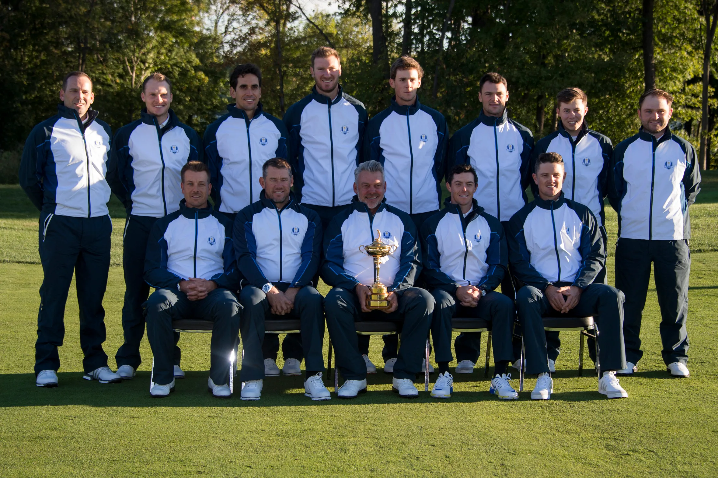 The European Ryder Cup team, including captain Darren Clarke holding the Ryder Cup, posing for a group photo.