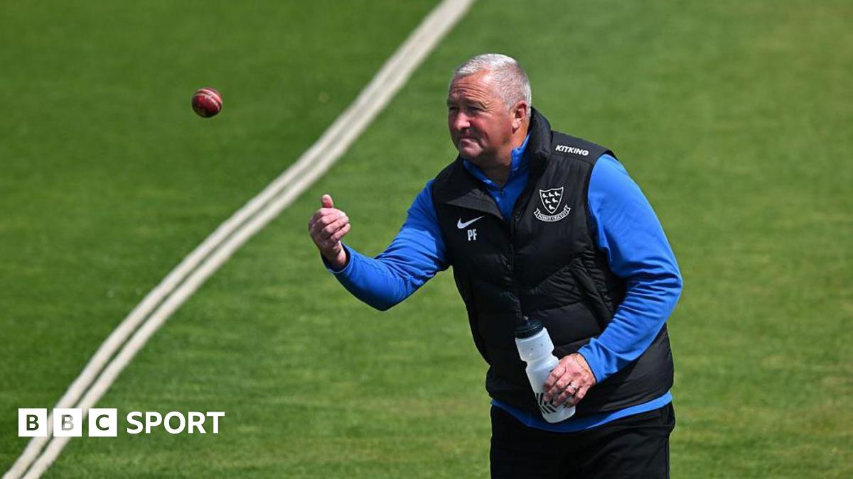 Paul Farbrace throws a ball underarm near a boundary rope in training with a water bottle in his other hand