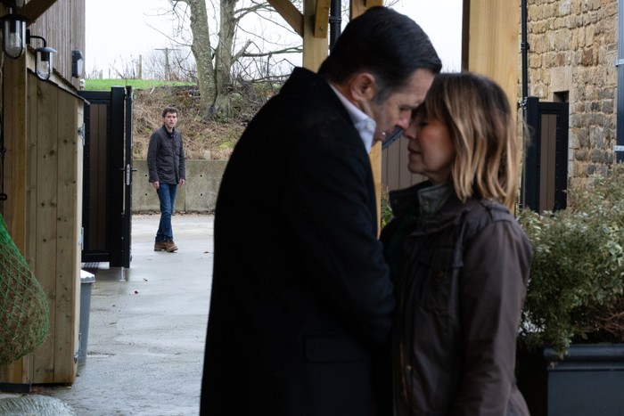 Marlon watching in the distance as Graham and Rhona look close to kissing in Emmerdale