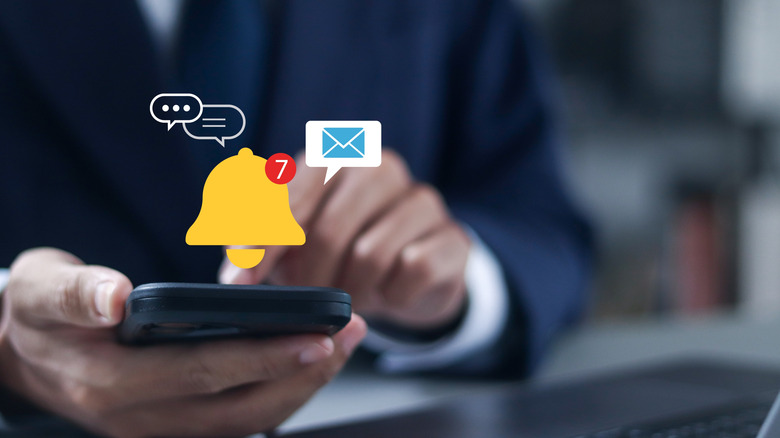A person holding a smartphone showing the notification bell symbol and a number next to message and email bubbles