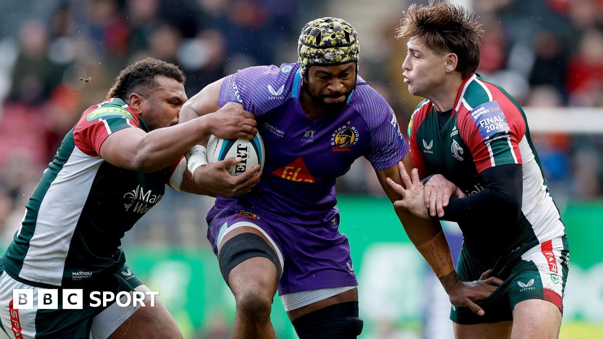 Exeter Chiefs' Christ Tshiunza bursts through the challenges of two Leicester Tigers players