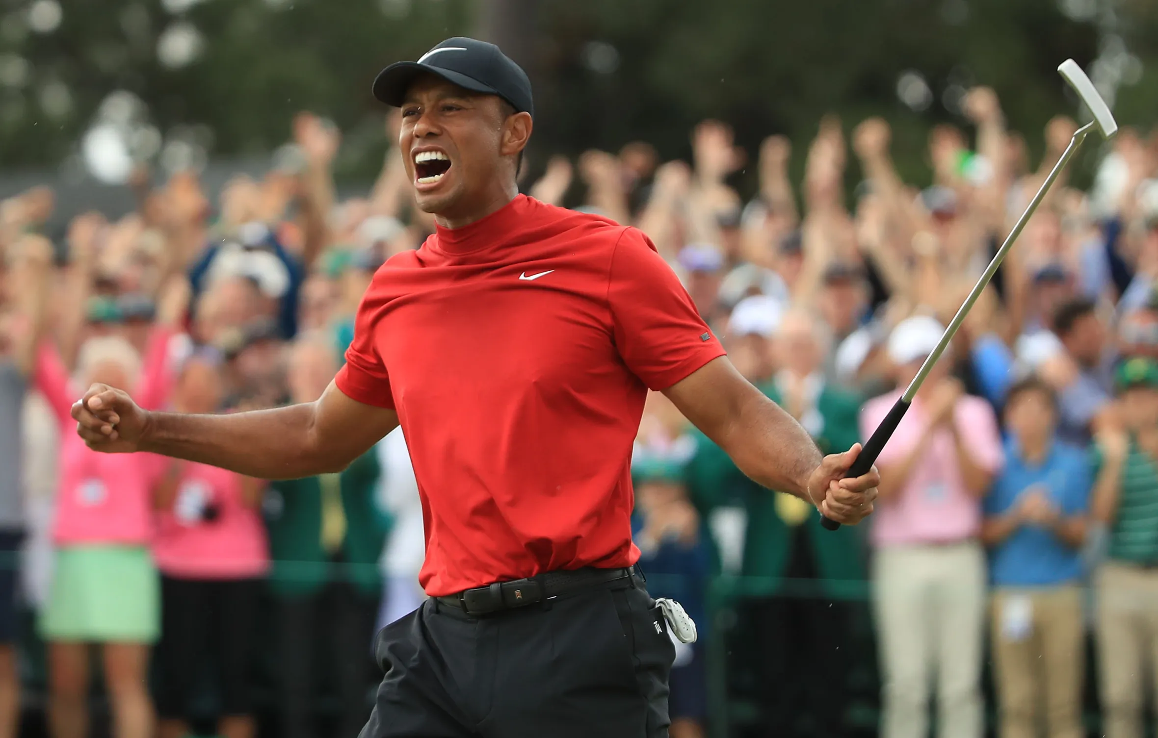 Tiger Woods celebrating on the 18th green after winning the Masters.
