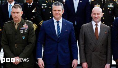 US Secretary of Defence Pete Hegseth standing in a blue suit and tie.