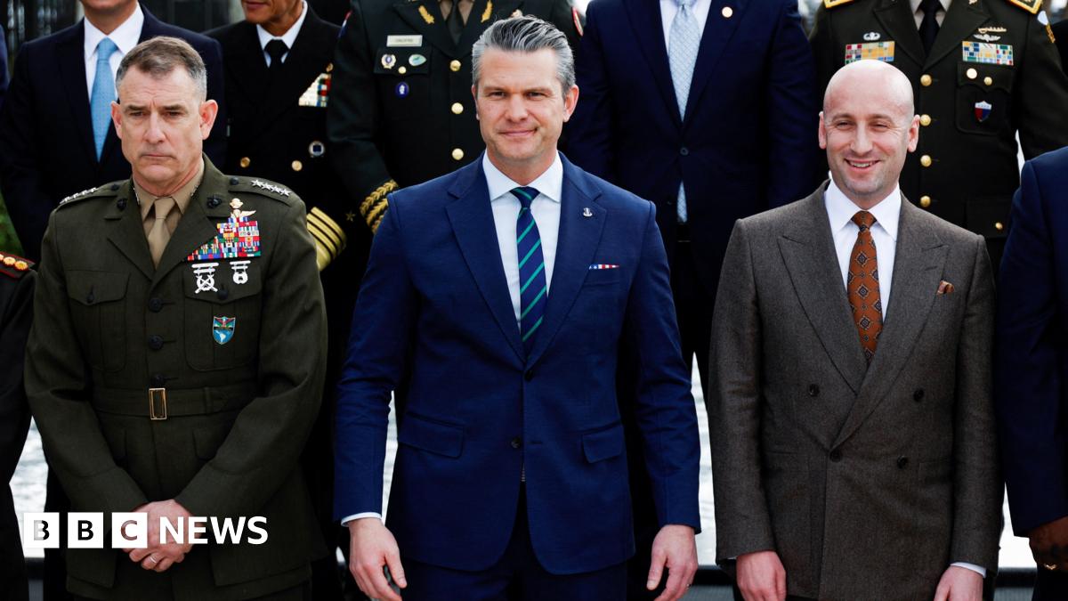US Secretary of Defence Pete Hegseth standing in a blue suit and tie.