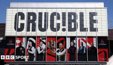 Sheffield's Crucible Theatre during the World Snooker Championship, featuring large pictures of players covering large windows on the building