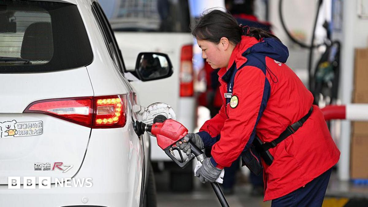 A worker refills a car at a gas station in Nanjing in eastern China's Jiangsu Province, Monday