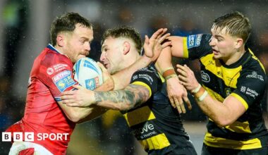 Hull KR winger Joe Burgess (left), with the ball under his right arm, is held up and tackled by York duo Liam Harris (centre) and Oli Field (right)