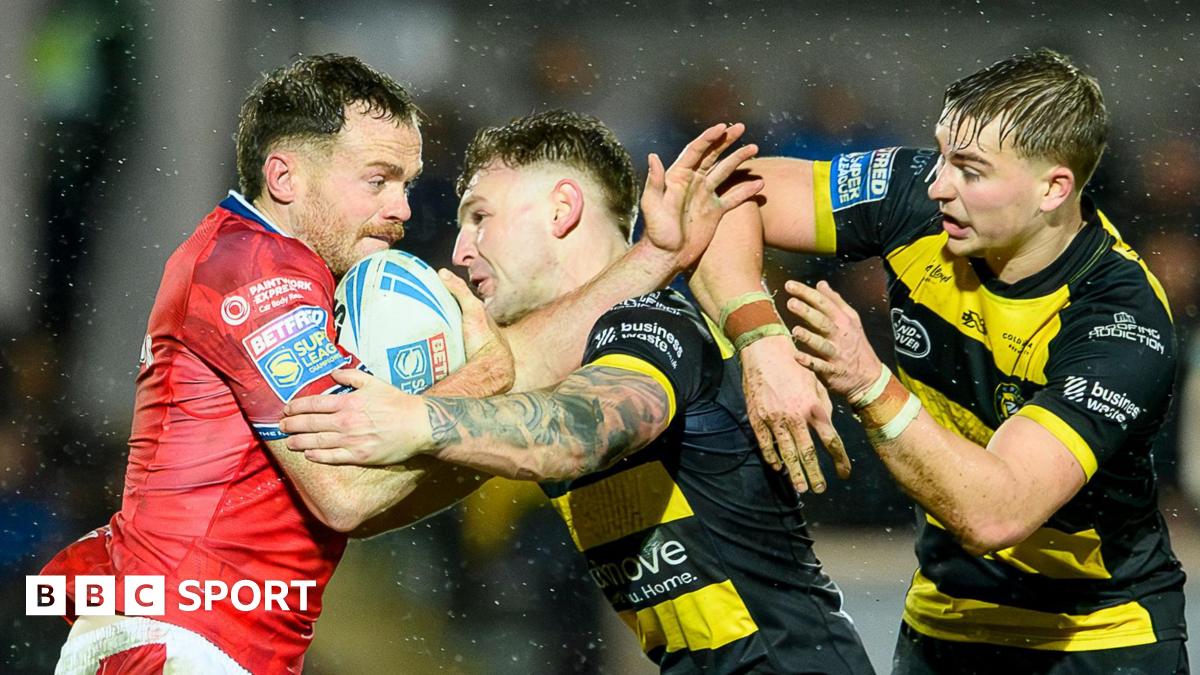 Hull KR winger Joe Burgess (left), with the ball under his right arm, is held up and tackled by York duo Liam Harris (centre) and Oli Field (right)