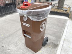 A brown plastic bin labeled 'food scraps, yard waste.'